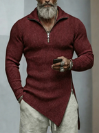 Man wearing a burgundy sweater with a zipper, holding a phone, against a neutral background