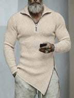 Man wearing a beige ribbed sweater with a zipper, holding a phone, on a gray background