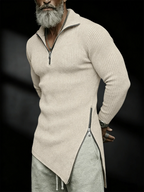 Man wearing a beige ribbed sweater with a zipper and gray pants on a black background