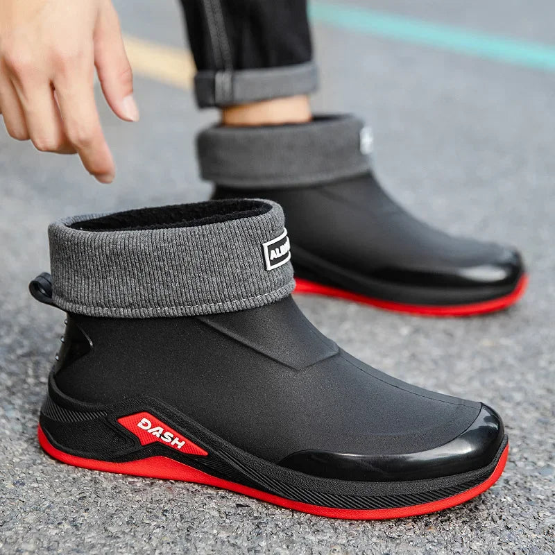 Black and red rain boots with gray cuffs on a gray surface
