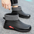Black and gray ankle boots with a brand logo on a concrete surface