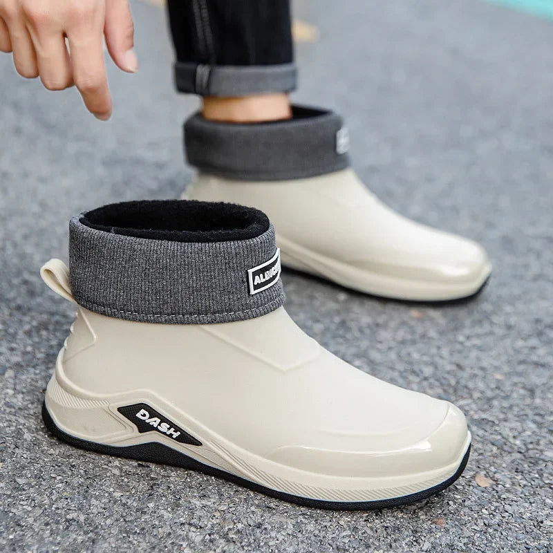 White rain boots with gray cuffs on a gray pavement background