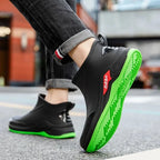 Black shoes with green soles worn by a person on a blurred street background