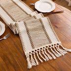 Textured table runner with tassels on a wooden table.