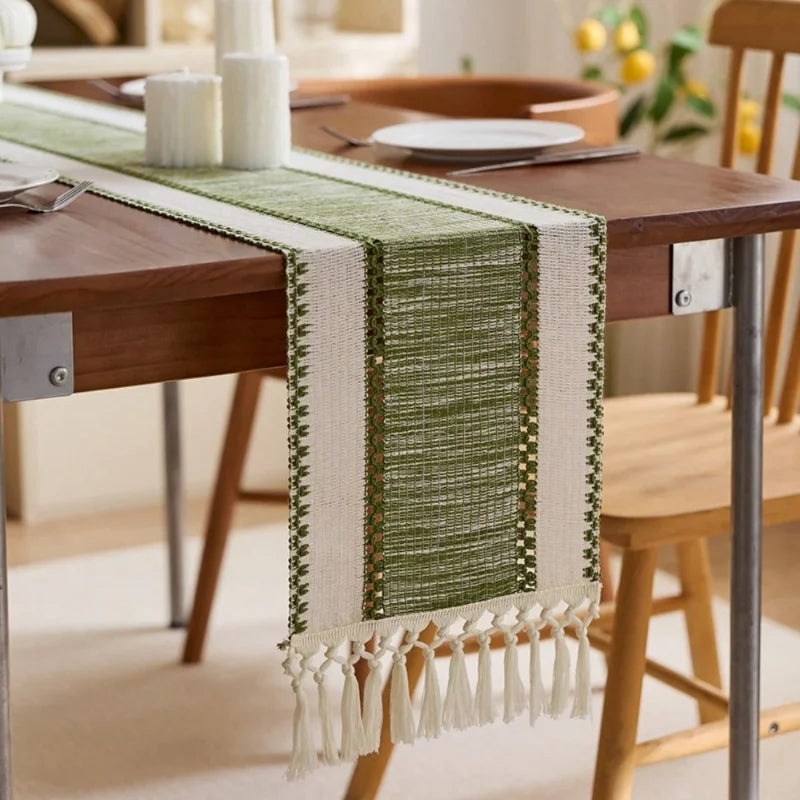 Green and white woven table runner on a wooden dining table with chairs.
