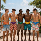 Five men standing together outdoors by the pool wearing colorful swim trunks. The trunks feature various patterns including stripes, geometric prints, leopard print, zebra print, and a pink flamingo design, each with a white drawstring waistband.