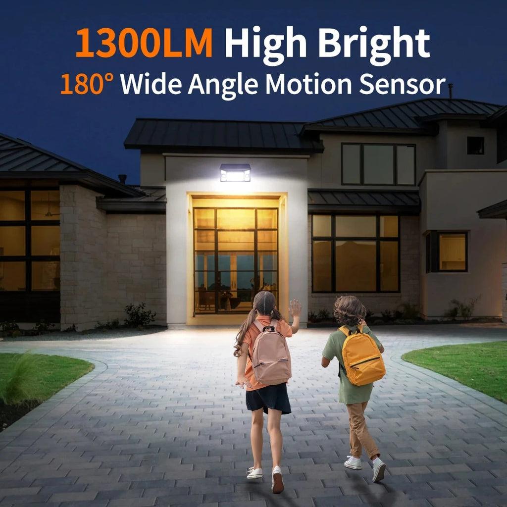 Two children at a house with a security light labeled '1300LM High Bright 180° Wide Angle Motion Sensor'.