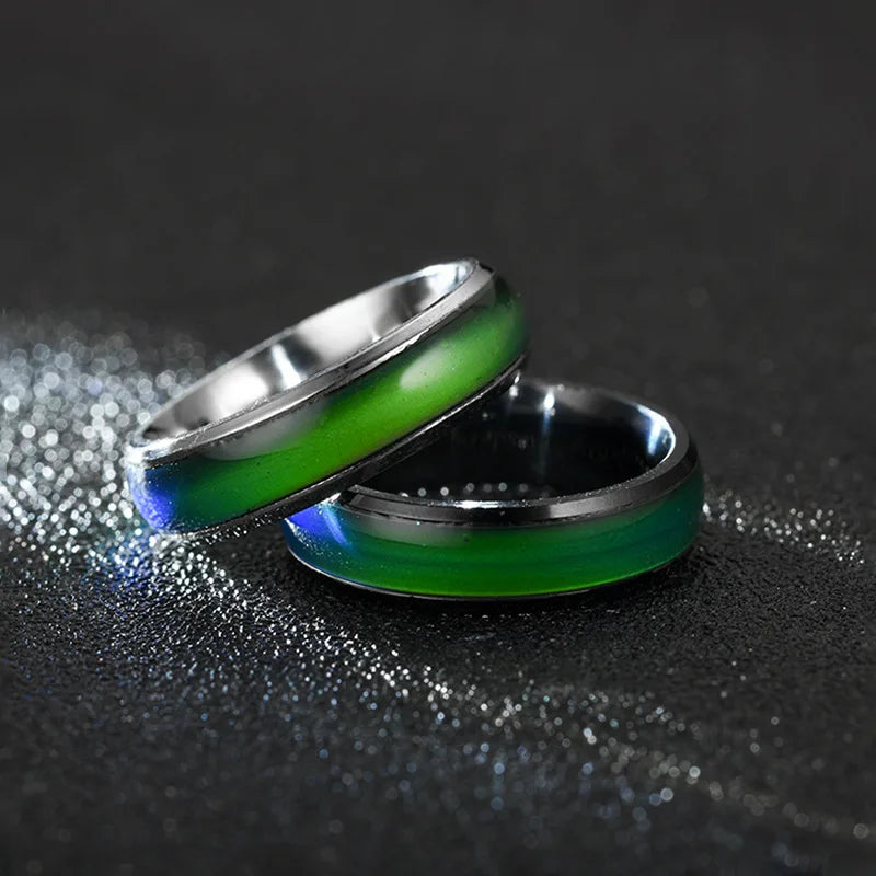 Two metallic rings with green interior on a dark background