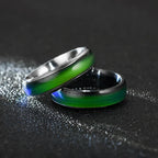 Two metallic rings with green interior on a dark background