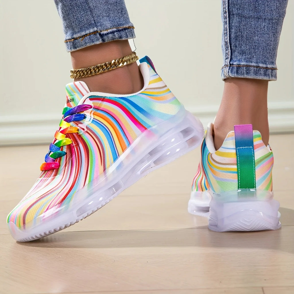 Colorful rainbow-patterned sneakers on a light wooden floor.
