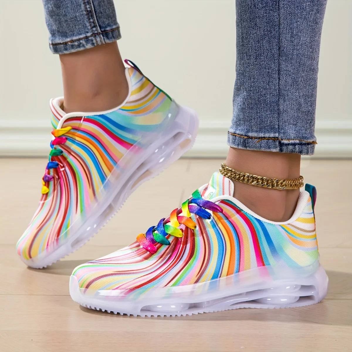 Colorful rain boots with rainbow patterns worn by a person on a light wooden floor.