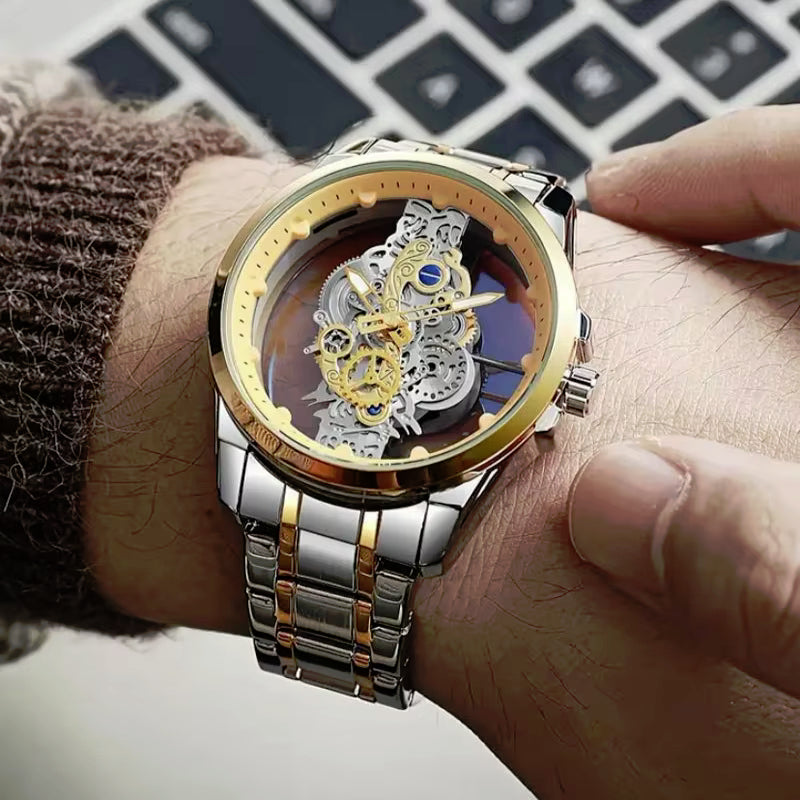 A close-up of a men's skeleton wristwatch with a gold and silver-tone metal case and link bracelet, worn on a person's wrist. The watch face is open, showing a detailed gold and silver mechanical movement.