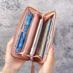 Open pink wallet with various cards and a phone on a gray textured background