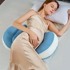Woman sleeping with a blue and white U-shaped pillow on a bed.