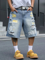 Light blue distressed denim shorts with yellow and white graphic patches, worn by a model with a white t-shirt, white socks, and yellow shoes.