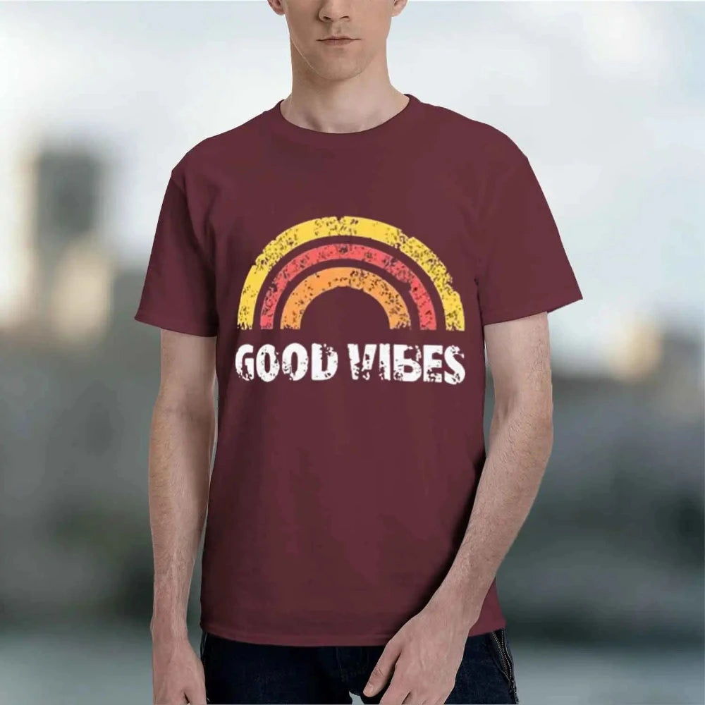A man wearing a maroon burgundy t-shirt with a distressed retro rainbow graphic and the words 'GOOD VIBES' printed in white across the chest.