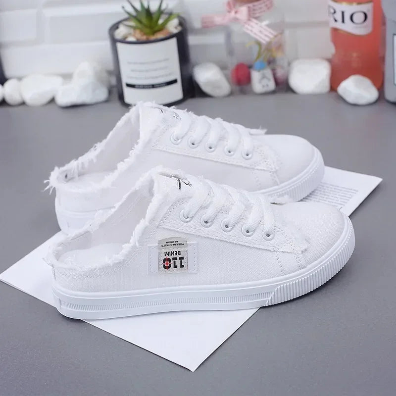 White slip on shoes slides half sneakers on a gray surface with a blurred background