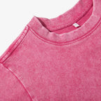 Close-up of a pink sweatshirt with a brand label on a white background