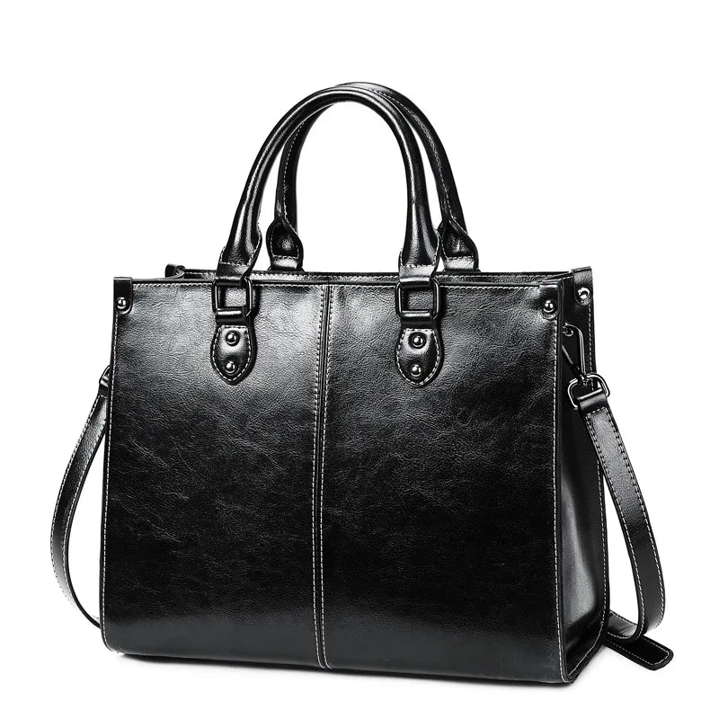 Black leather handbag with shoulder strap on a white background