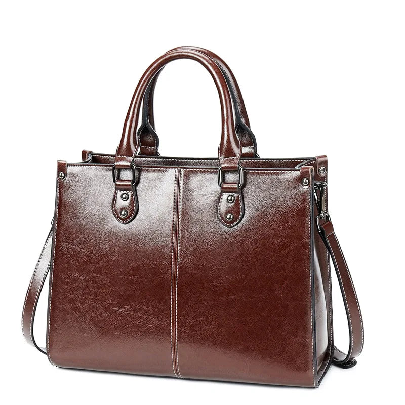 Brown leather handbag with a shoulder strap on a white background