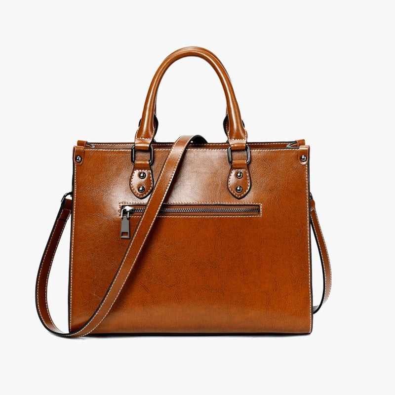 Brown leather handbag with a shoulder strap on a white background