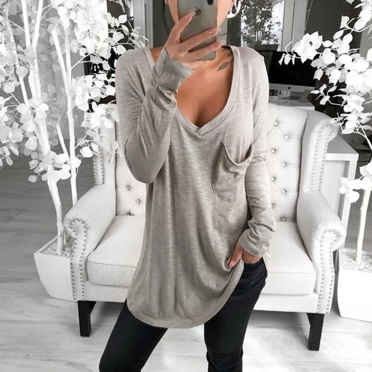 Woman wearing a long, loose-fitting gray long sleeve t-shirt. 