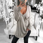 Woman wearing a long, loose-fitting gray long sleeve t-shirt. 