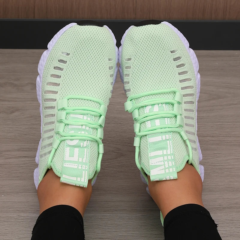 Light green women's running walking casual sneakers shoes worn on a wooden floor.