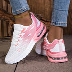 Pink and white sneakers worn with blue jeans on a neutral background