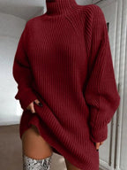 Person wearing a red sweater with a high neckline and long sleeves.