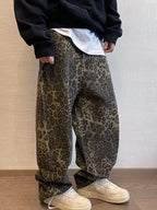 Person wearing leopard print pants and beige shoes against a neutral background